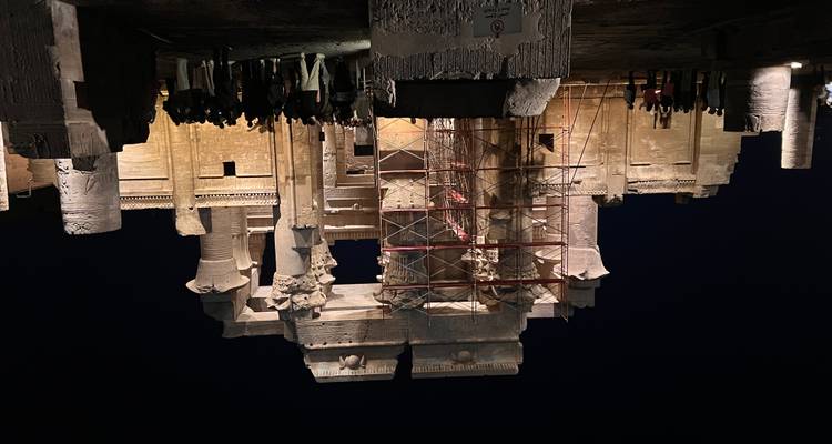 Un temple égyptien antique illuminé la nuit avec une foule de visiteurs.
