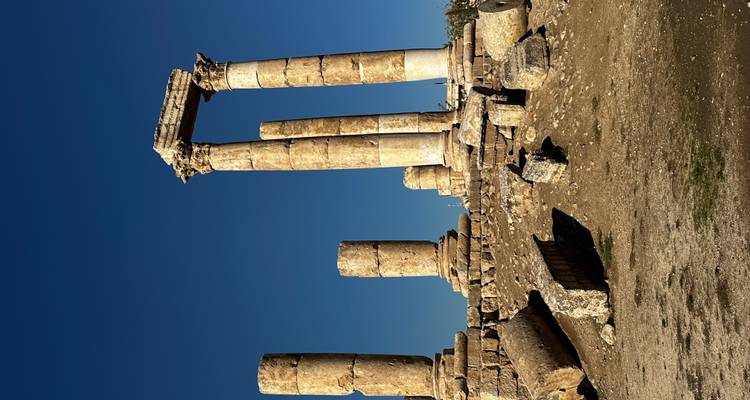Colonnes en ruines d'un site historique sous un ciel bleu dégagé.
