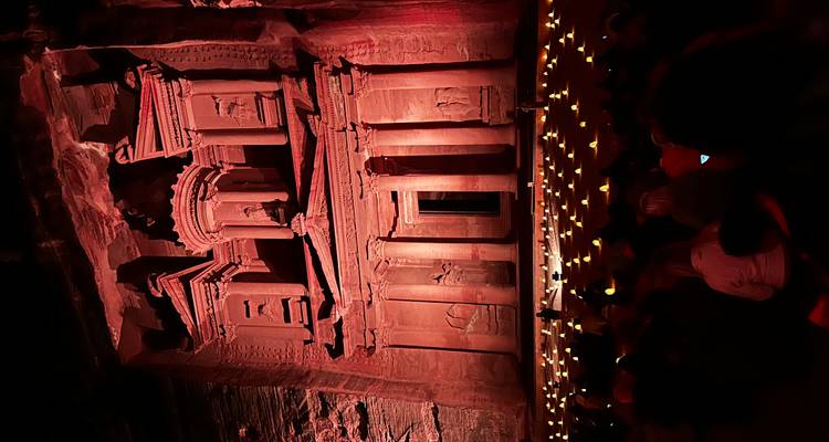 Façade du trésor de Pétra illuminée la nuit avec un public assis.