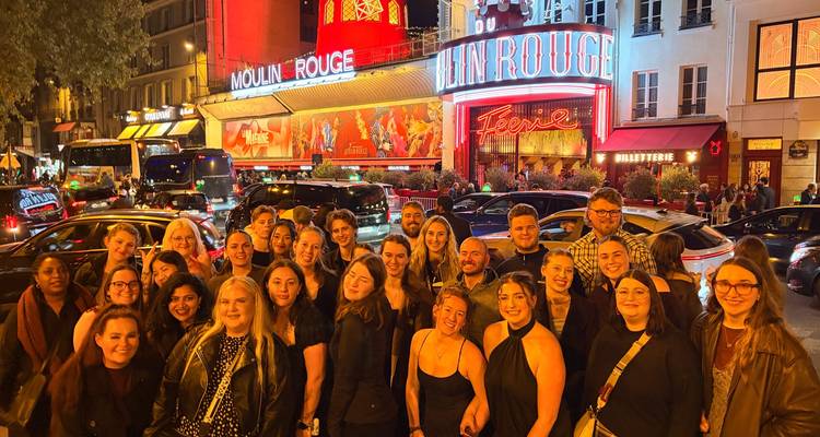 Grupo disfrutando de la vida nocturna en el Moulin Rouge.