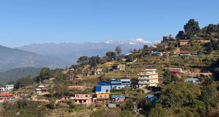 Bergdorf mit bunten Häusern und Bergkulisse.