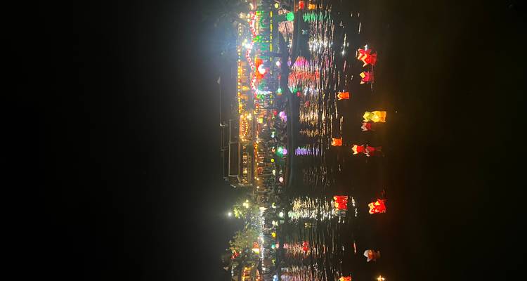 Laternen, die nachts mit leuchtenden Lichtern auf einem Fluss treiben.