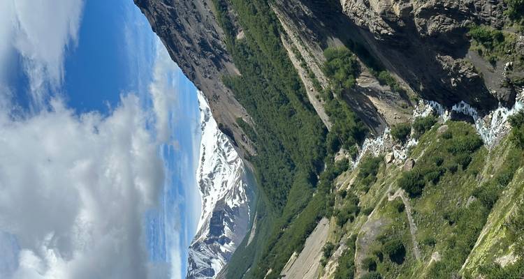 A valley with a river and distant snow-covered peaks.