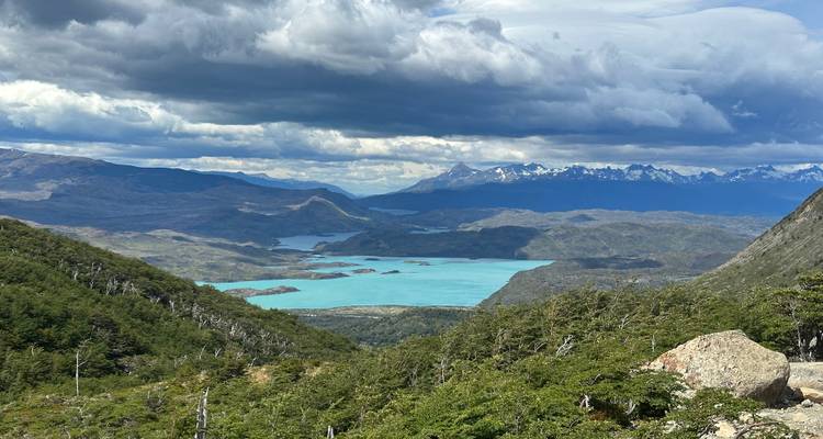 A vast landscape with mountains and a turquoise lake.