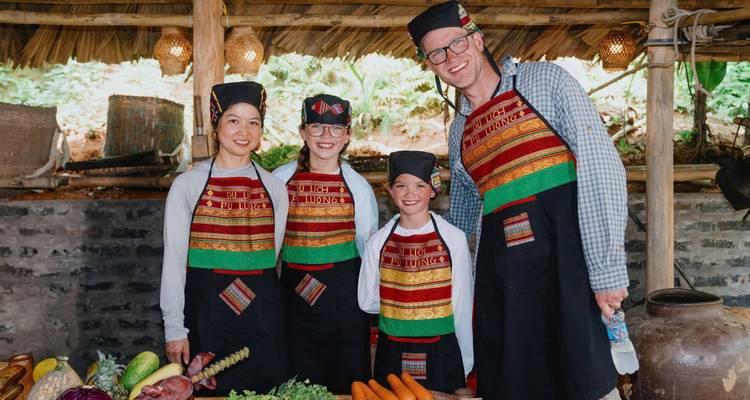 Famille posant avec des vêtements de cuisine traditionnels et des légumes.