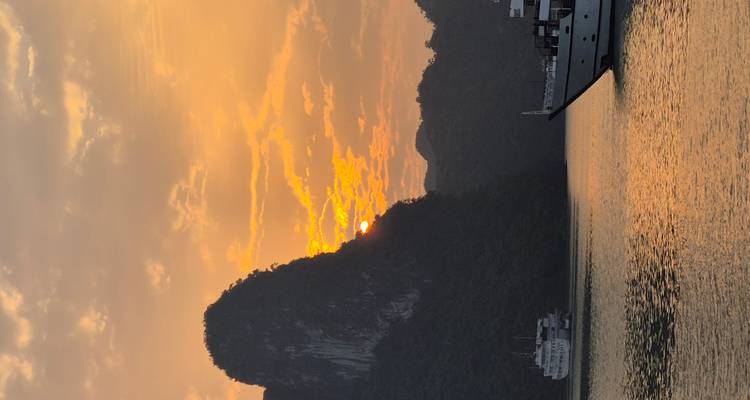 Zonsondergangzicht over Halong Bay met boten.