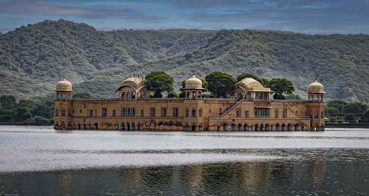 Jal Mahal, un palais situé au milieu d'un lac avec des collines environnantes.