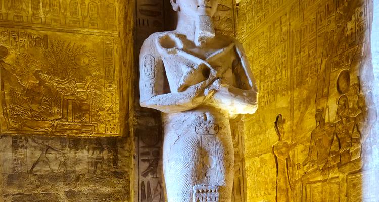 Well-lit interior of an ancient Egyptian temple with carvings and statues.