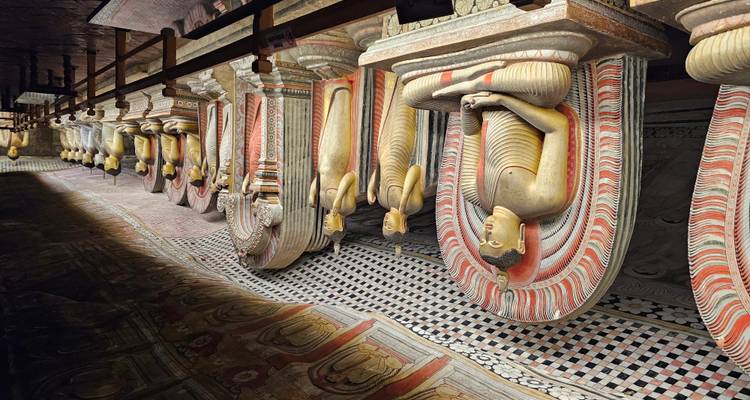 Filas de estatuas de Buda en un templo cueva con poca iluminación.