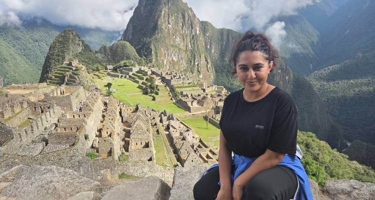 Woman sitting with Machu Picchu in the background.