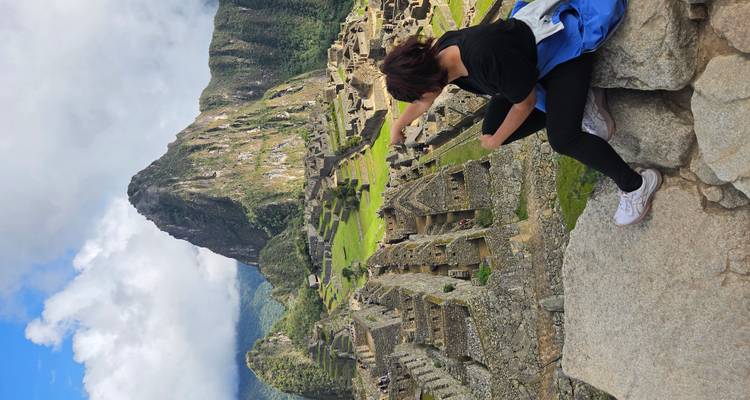 Person pointing at Machu Picchu ruins.