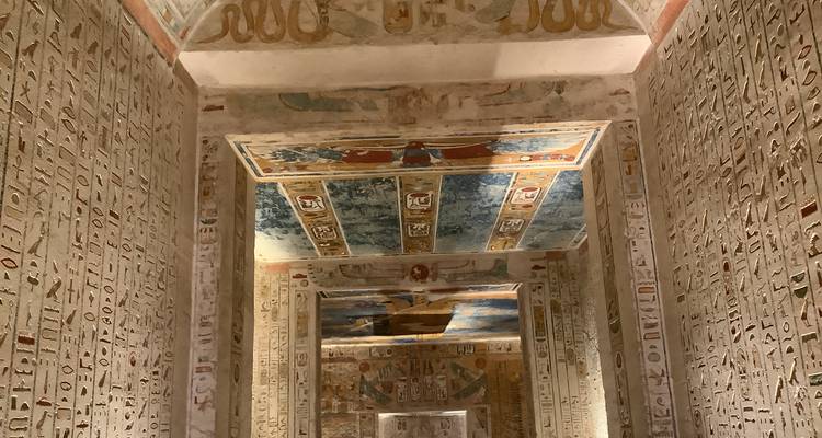 Interior of an ancient Egyptian tomb with hieroglyphics and colorful paintings on the walls.