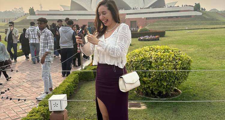 Touriste pose joyeusement devant un célèbre monument en forme de lotus.