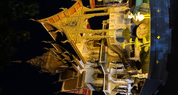 Templo ornamentado iluminado por la noche con arquitectura intrincada.