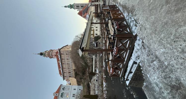 Vista de un Cesky Krumlov nevado con un castillo.