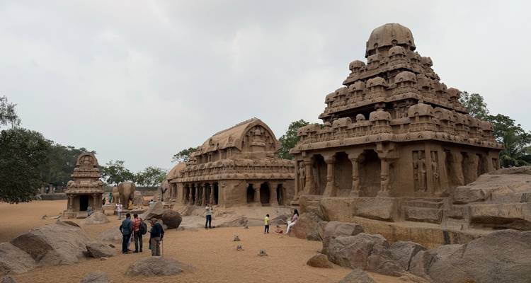 Groupe de temples en pierre historiques avec des personnes qui explorent.