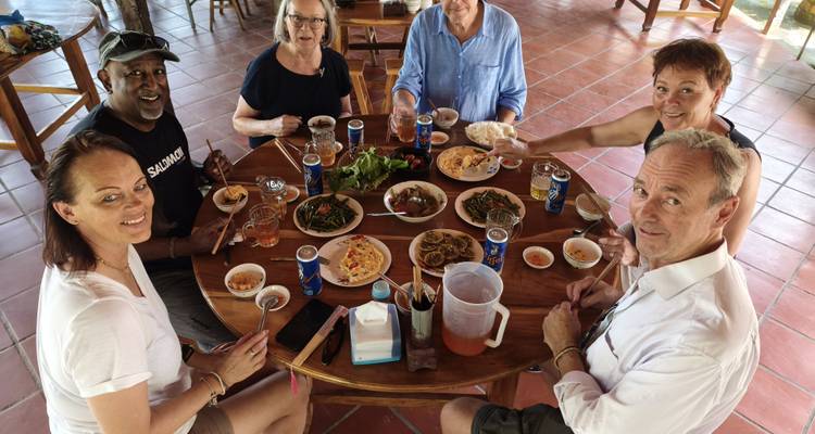 Tourists enjoying a meal together at a table filled with traditional food.