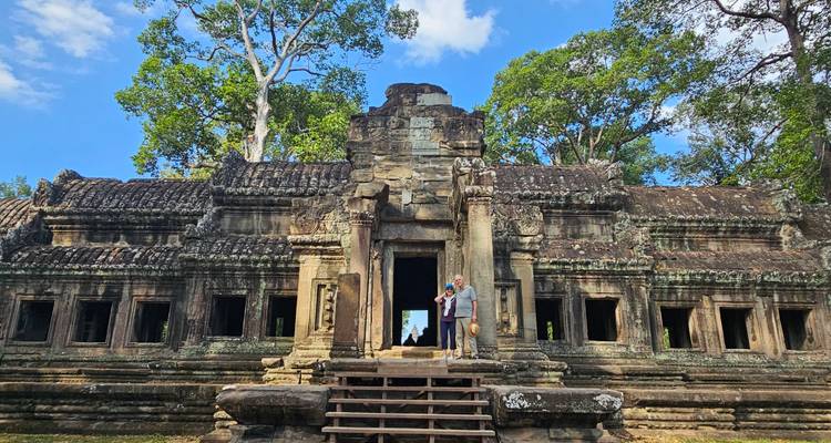 Two people posing in front of an ancient temple ruin.