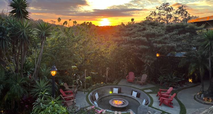 Sonnenuntergang mit Blick auf einen Garten mit einer Feuerstelle.