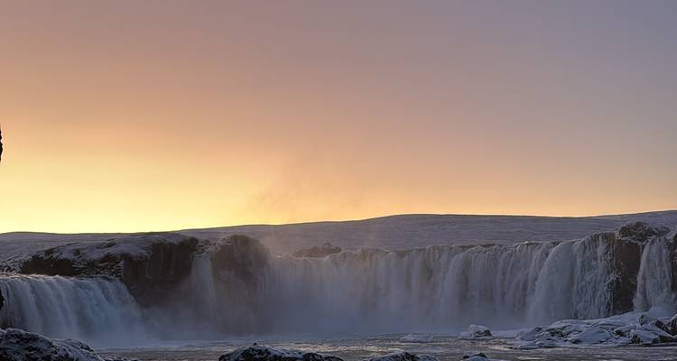Cascada con resplandor del atardecer detrás.
