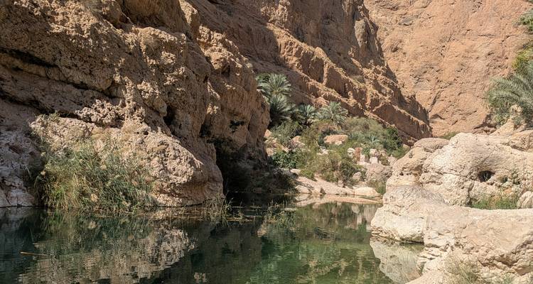 Vue panoramique d'un canyon rocheux avec un reflet à la surface de l'eau.