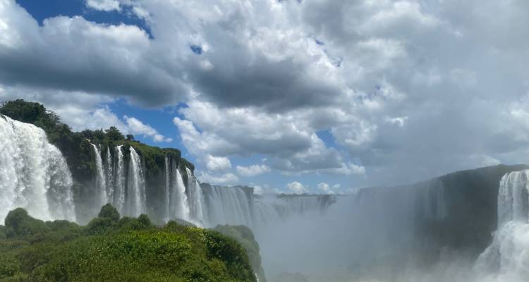 Vue spectaculaire des chutes d'Iguazu avec brume et végétation luxuriante.