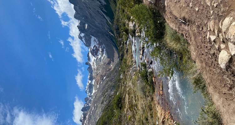 Une rivière coulant à travers un paysage montagneux avec des sommets enneigés.