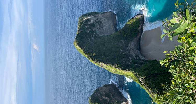 Luftaufnahme eines atemberaubenden Strandes an einer Klippe mit klarem, blauem Wasser.