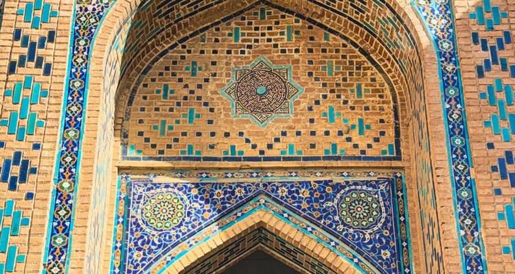 Primer plano de un arco decorado con azulejos azules y dorados en un edificio histórico.