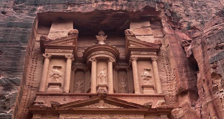 Primer plano de la icónica fachada del Tesoro de Petra tallada en acantilados de arenisca roja.