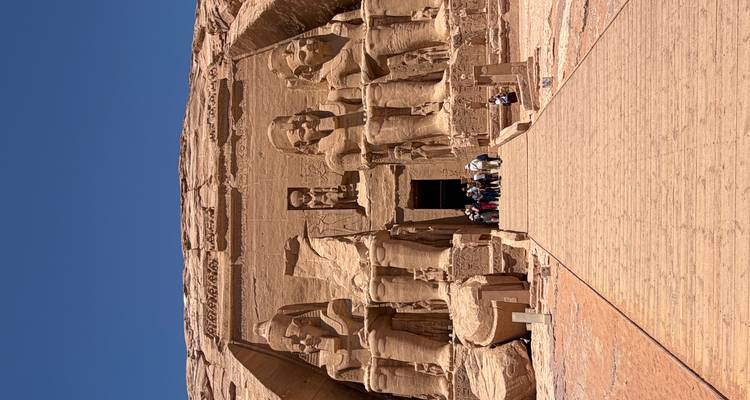 Große Fassade von Abu Simbel mit kolossalen sitzenden Statuen unter einem tiefblauen Himmel.