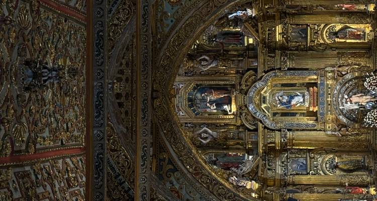 Altar barroco lujoso cubierto de pan de oro y estatuas religiosas dentro de una iglesia ornamentada.