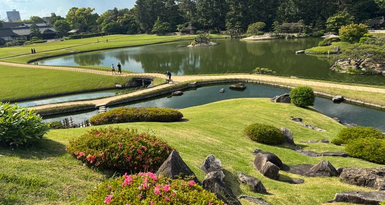 Hermoso jardín japonés con paisajismo, estanques, puentes curvos y arbustos florales