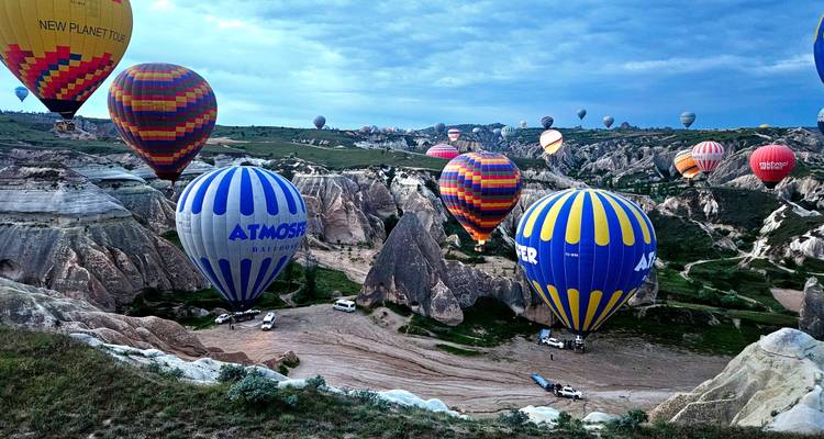 Des dizaines de montgolfières colorées dérivent au-dessus des formations rocheuses surréalistes de la Cappadoce à l'aube