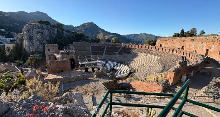Sweeping view of the ancient Greco-Roman theatre in Taormina with rugged cliffs and mountains behind
