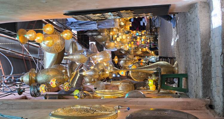 Angosto callejón de zoco lleno de linternas de latón brillantes y lámparas de cristal coloridas, creando una atmósfera mágica.