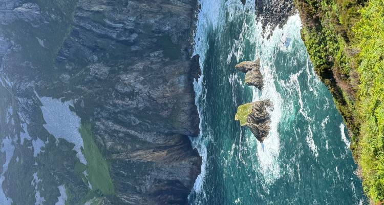 Rocky sea stacks surrounded by vivid turquoise waves at rugged coastline