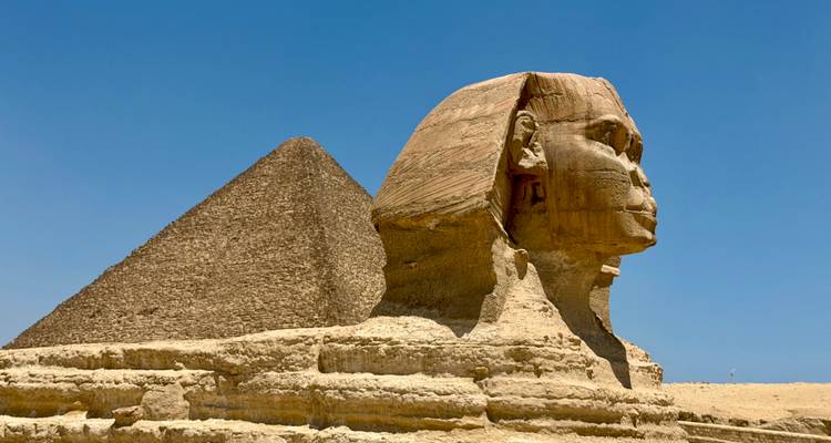 Iconic Great Sphinx with Khafre pyramid behind under a clear blue Egyptian sky