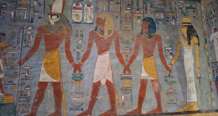Des bas-reliefs muraux colorés et détaillés de divinités égyptiennes anciennes à l'intérieur d'une tombe.