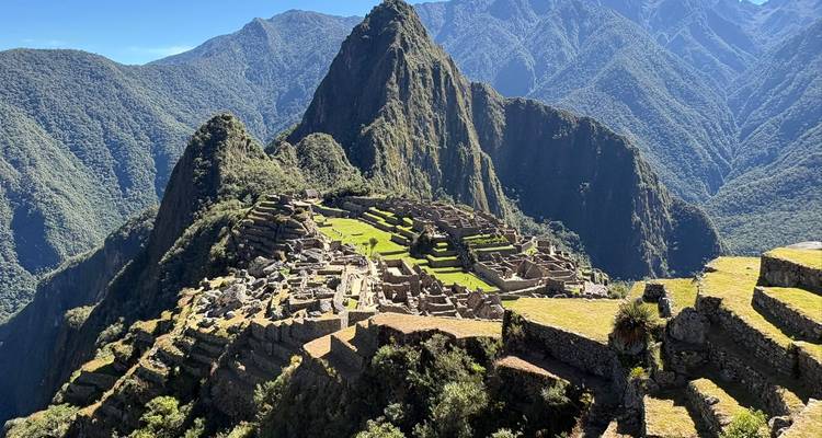Iconic panoramic view of Machu Picchu’s stone terraces and Huayna Picchu peak surrounded by rugged Andes mountains.