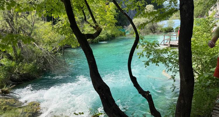 Emerald river and cascades surrounded by lush greenery at Plitvice Lakes