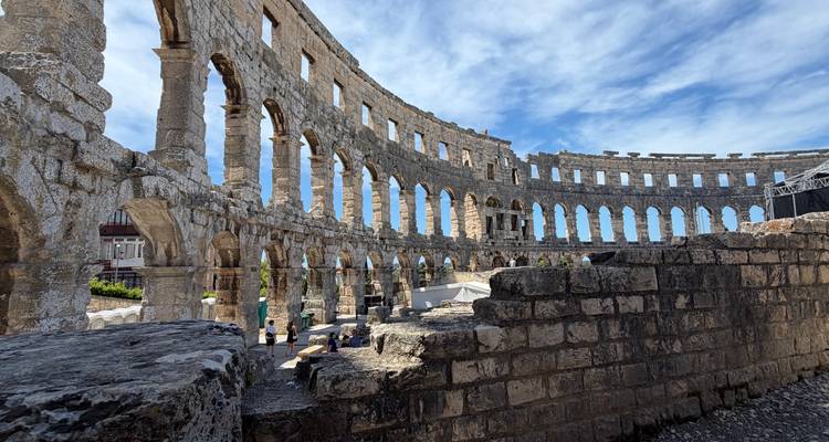 Ancient Roman amphitheater in Pula under a dramatic blue sky