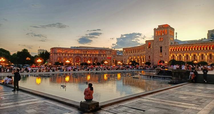 Evening scene at Republic Square Yerevan with fountains and crowds under golden light
