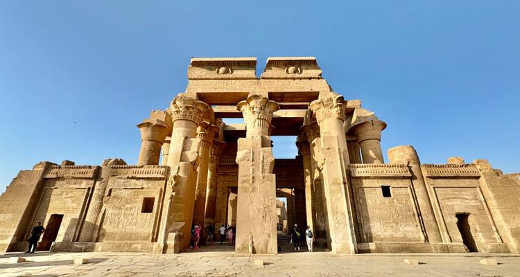 La entrada monumental y las columnas imponentes del Templo de Kom Ombo bajo un cielo azul despejado.