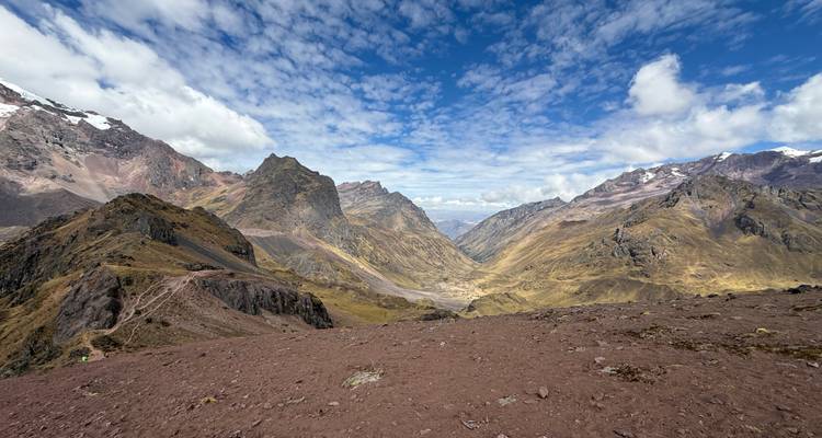 Wide Andean mountain panorama under a sky dotted with dramatic clouds.