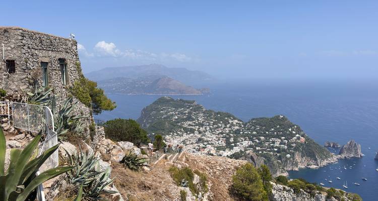 Sweeping view from a cliff-top on Capri showing azure seas, Faraglioni rocks, and hillside villages.
