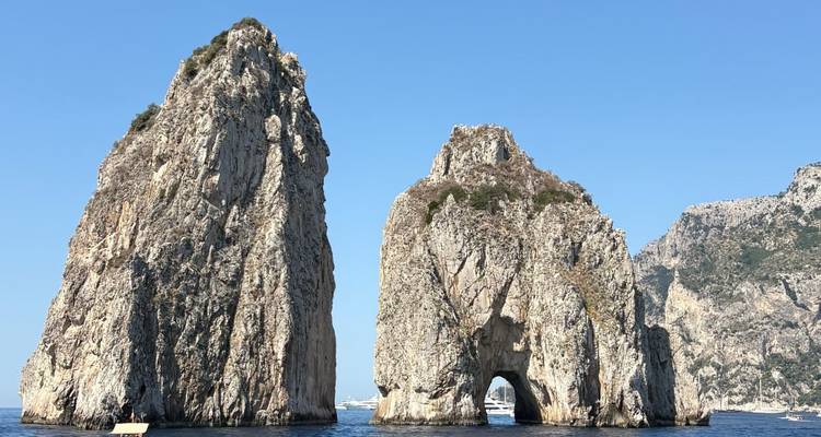 Iconic Faraglioni sea stacks rise dramatically from the blue waters off Capri.