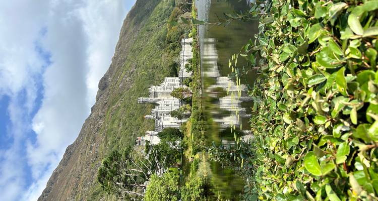 Elegant kasteel aan het meer dat zich weerspiegelt in het stille water met weelderige groenheid en een bergachtige achtergrond