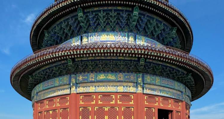 Vibrantly painted circular Hall of Prayer for Good Harvests rising against a clear blue sky.