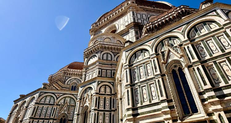 Façade en marbre ouvragé et dôme du Dôme de Florence sous un ciel bleu profond